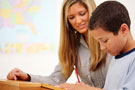 Teacher helping boy read